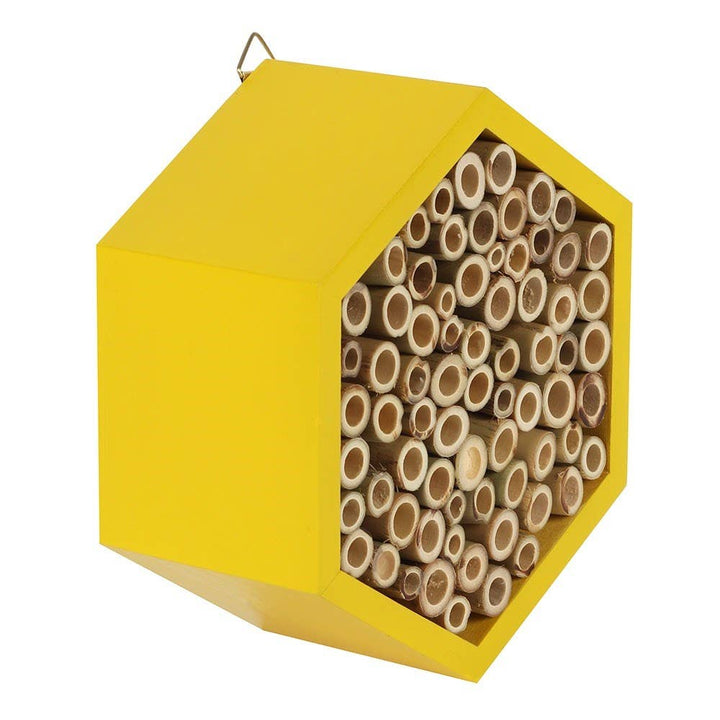 Hexagonal yellow bee house with wooden tubes inside on a white background