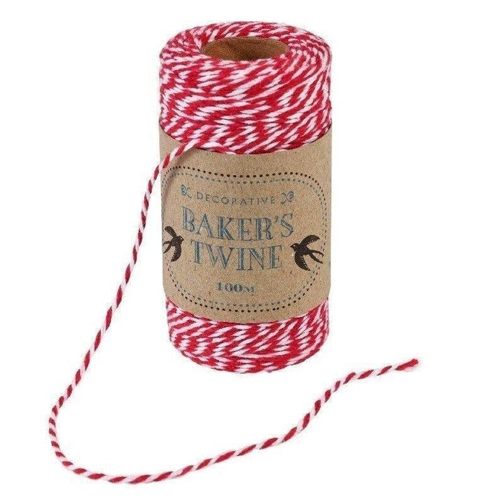 Spool of red and white baker's twine with a decorative label on a white background