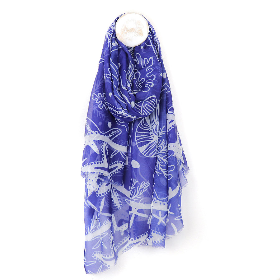 Blue scarf with white patterns on a mannequin head against a white background