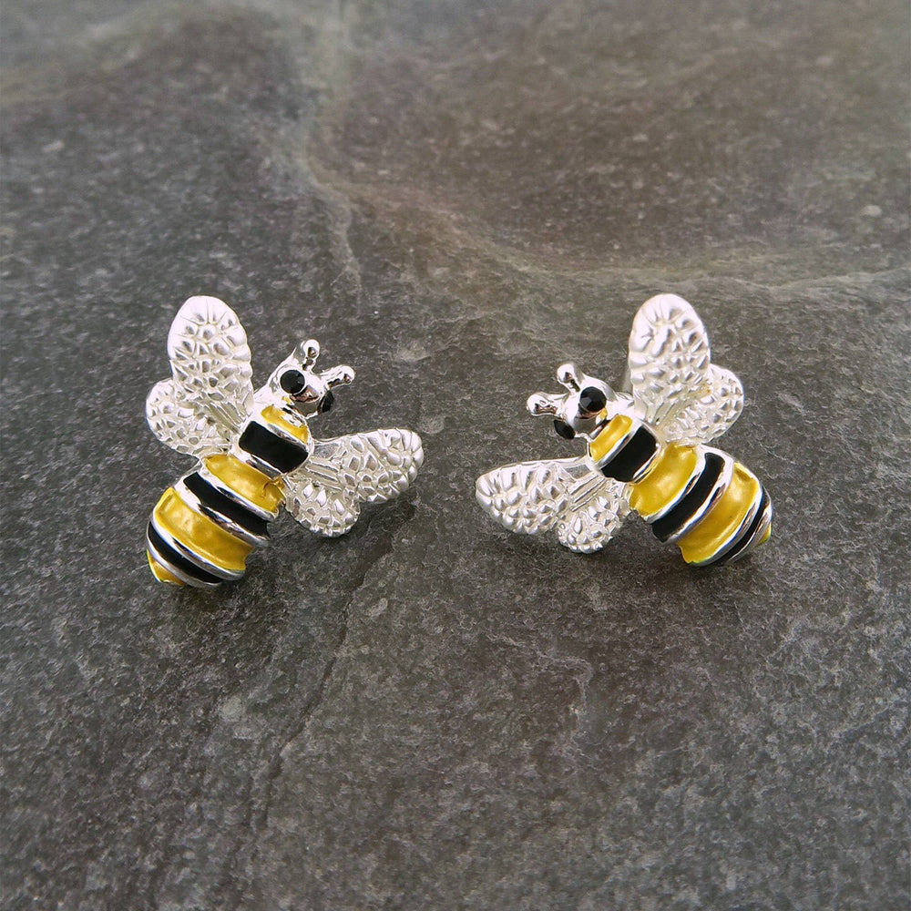 Bee-shaped earrings on a gray stone surface