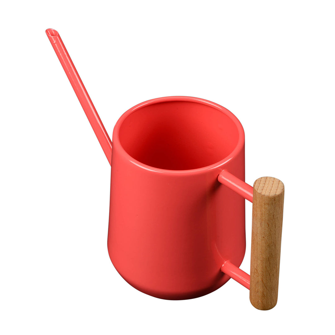Coral watering can with a wooden handle on a white background