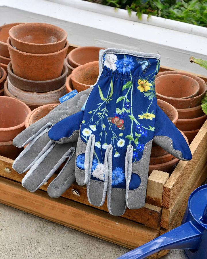Gardening gloves with floral design on a wooden tray with pots