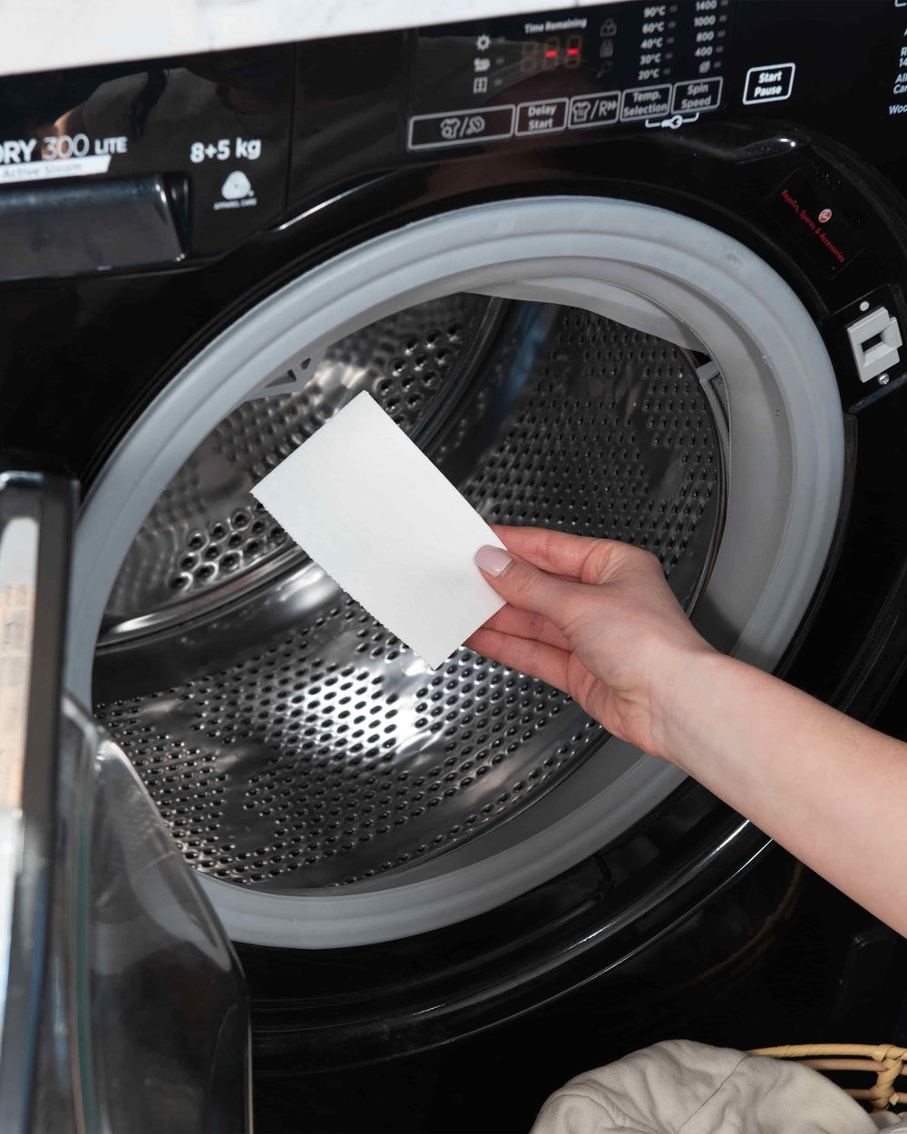 Person holding a piece of paper in front of an open dryer