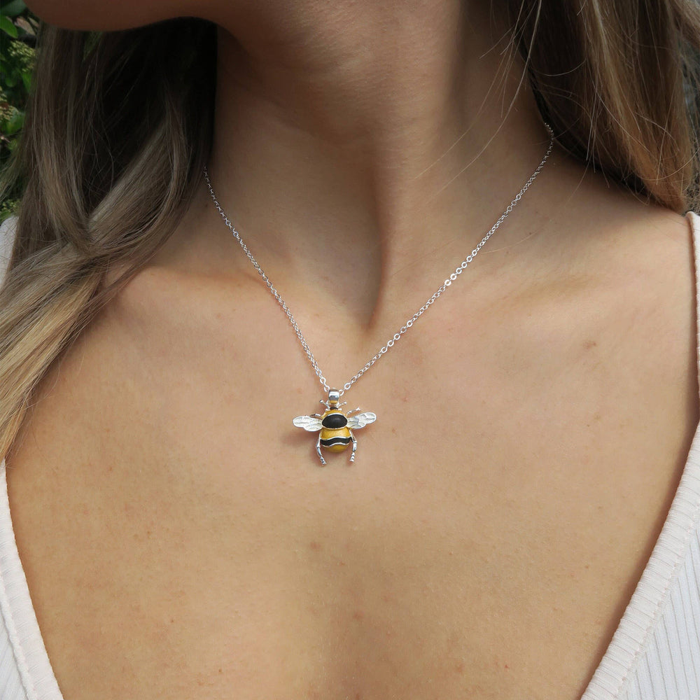 Necklace with a bee pendant worn by a person