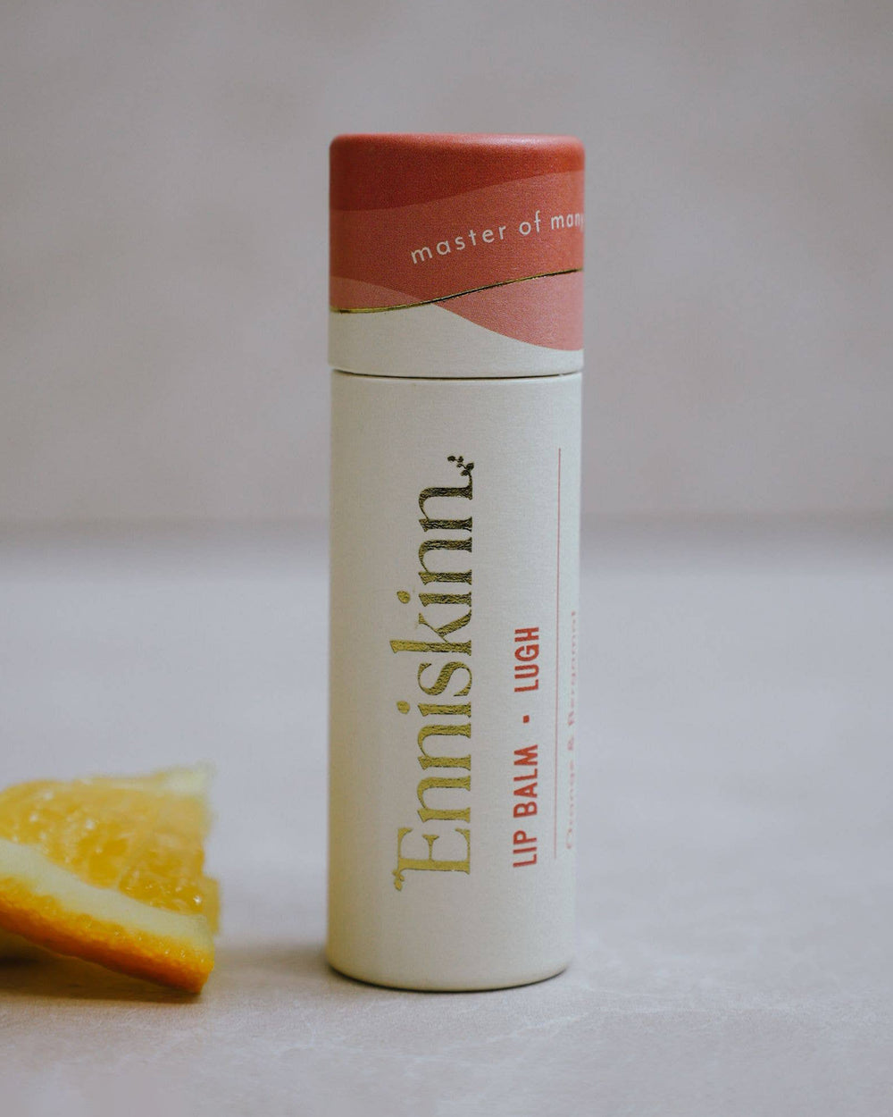Lip balm container with 'Enniskinn' branding on a light background