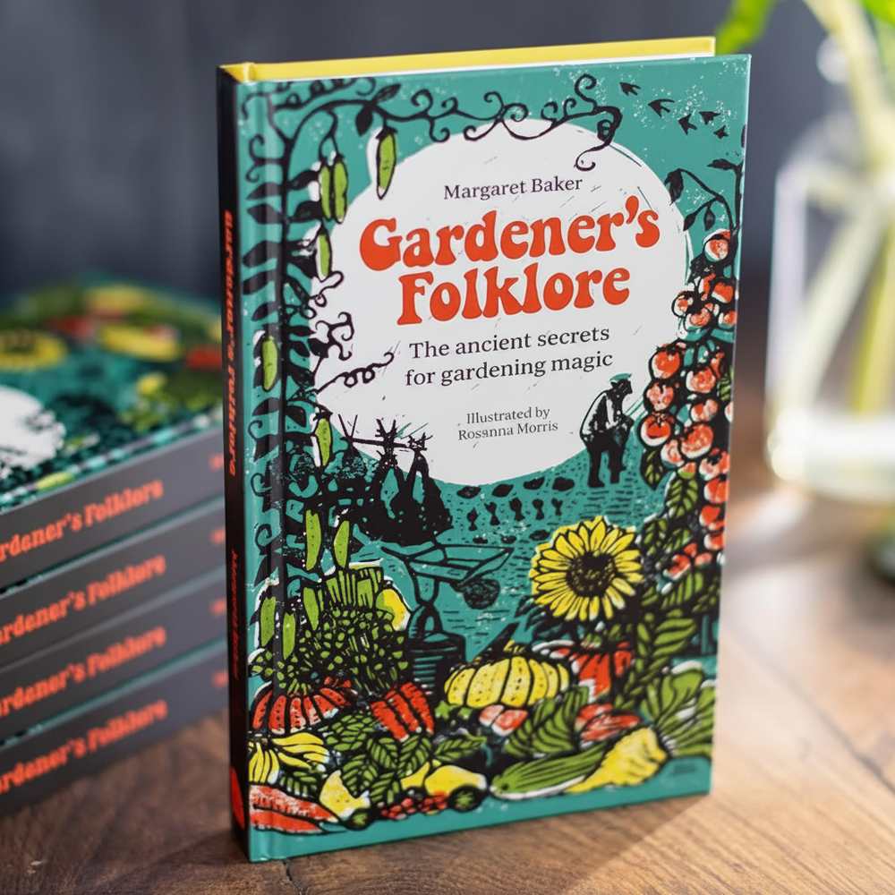 Book of Gardener's Folklore standing on a bench top with other copies of the boo kstacked behind