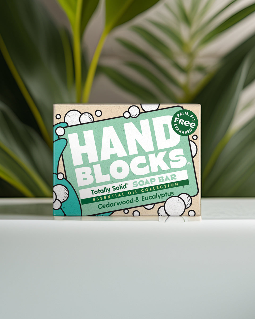 Hand Blocks soap bar packaging on a white surface with greenery in the background