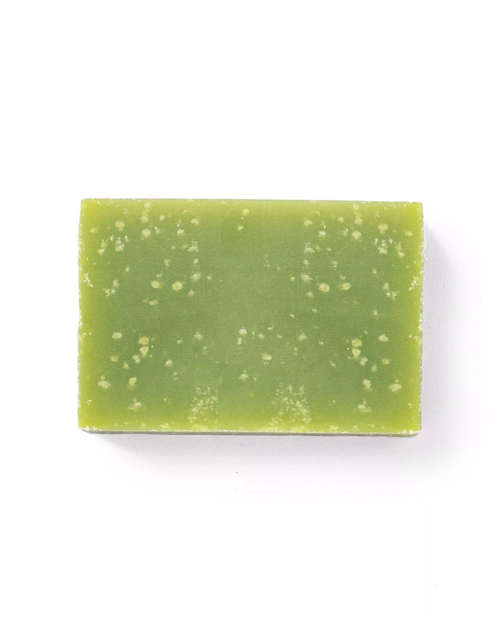 Green soap bar with speckles on a white background