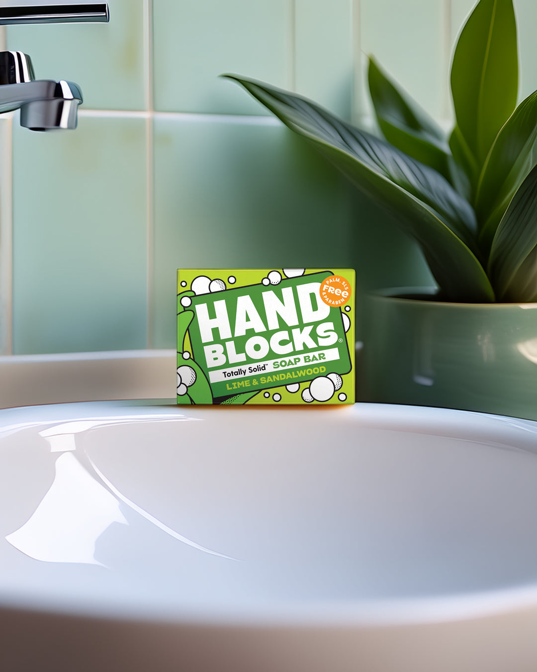 Hand Blocks soap bar packaging on a bathroom sink with a plant in the background
