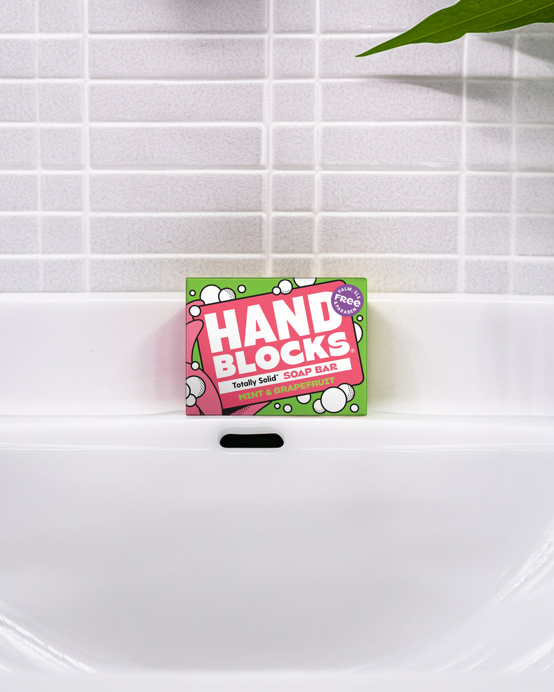 Hand Blocks soap bar packaging on a white sink with tiled wall background