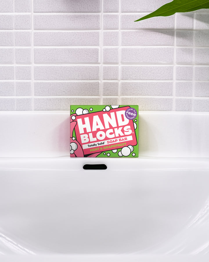 Hand Blocks soap bar packaging on a white sink with tiled wall background