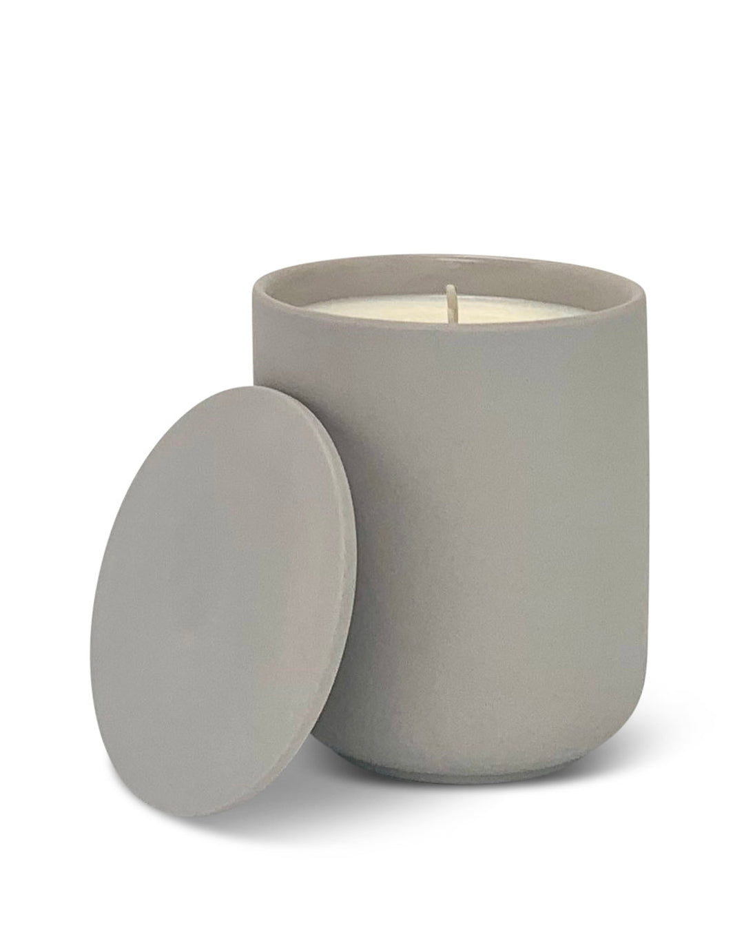 Gray candle in a container with a lid on a white background