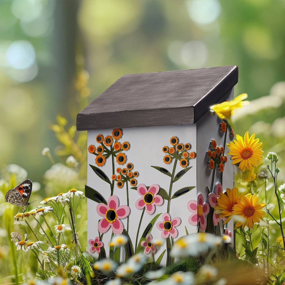 Decorative bee house with floral design in a garden setting