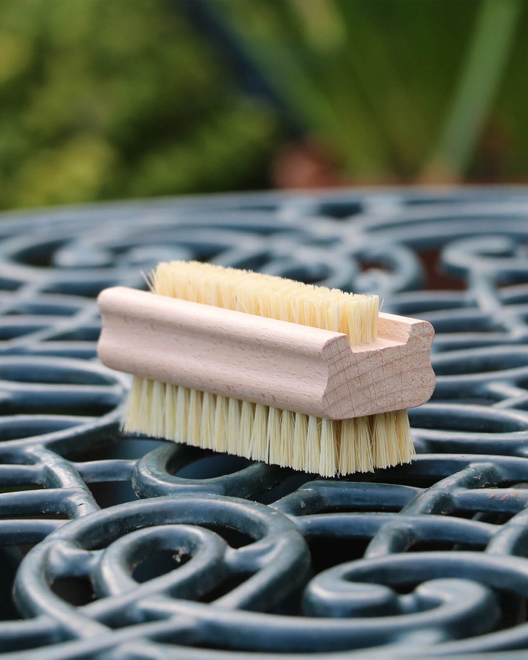 Brush with wooden handle and bristles on a metal surface
