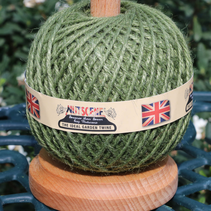 A ball of olive green twine wrapped with a paper band labeled &