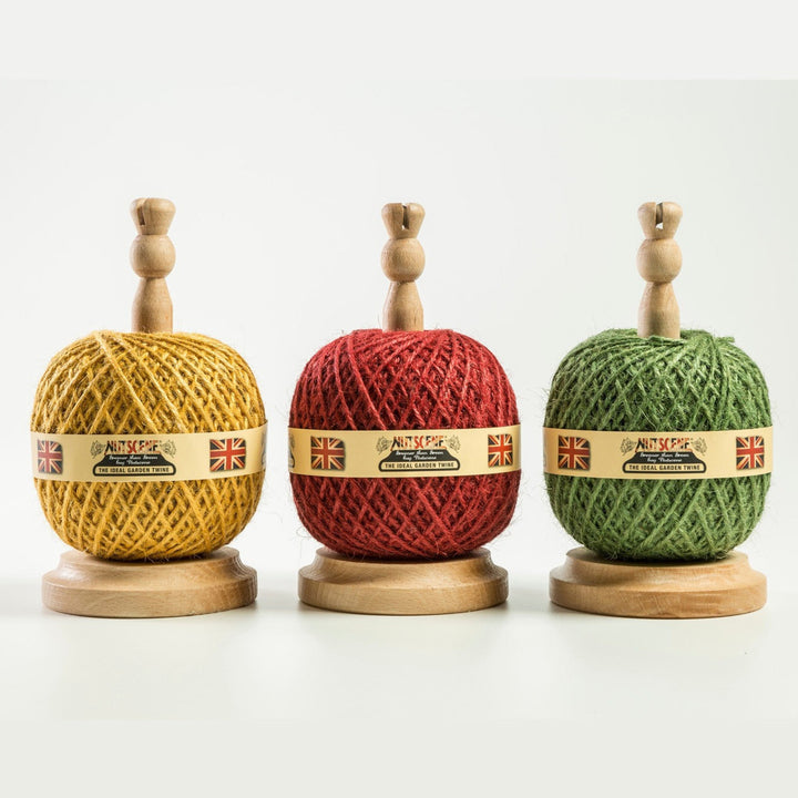 Three Nutscene beech wood twine holders with thistle top cutters, shown with gold, red and green jute twine