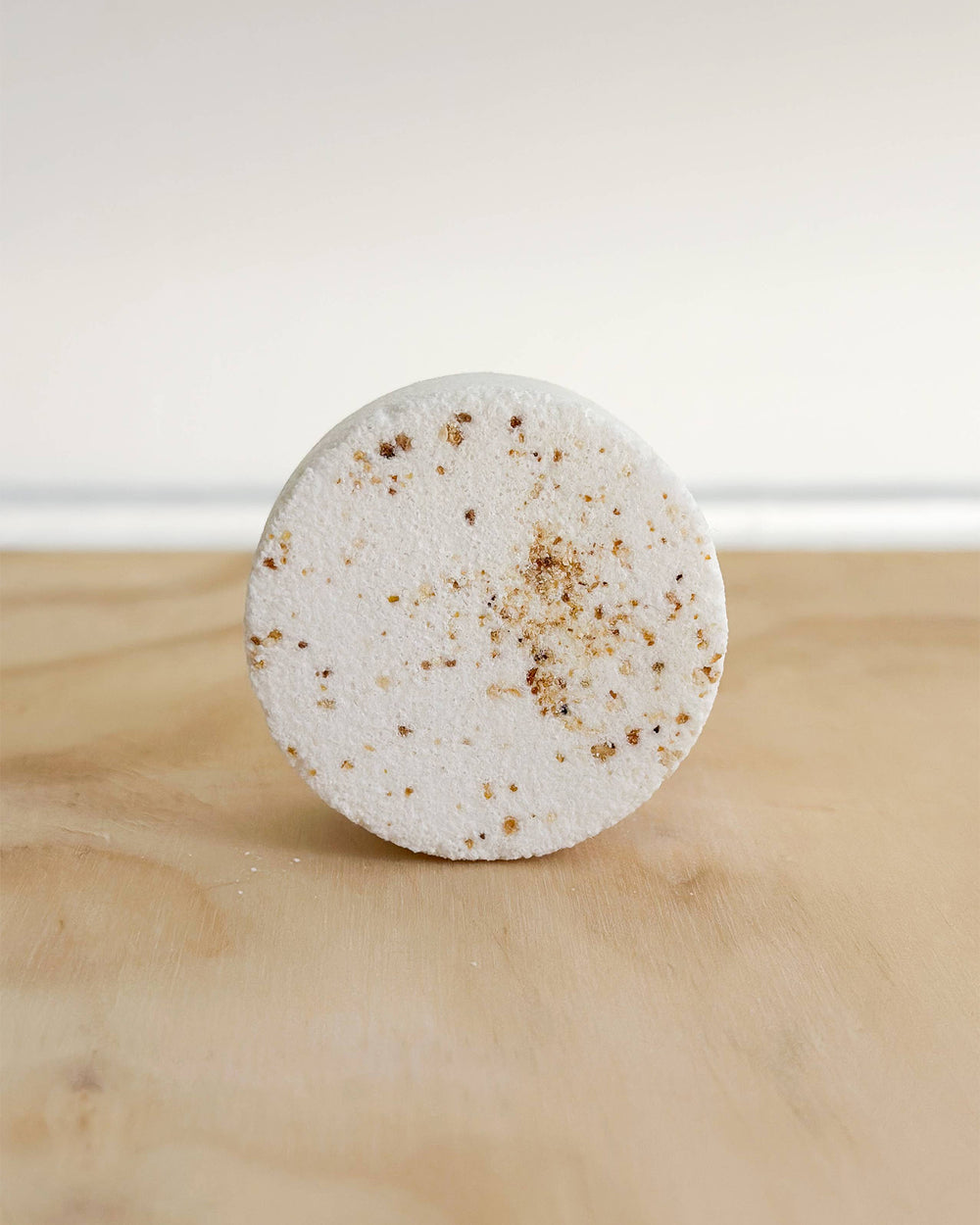 Round white bar with brown specks on a wooden surface