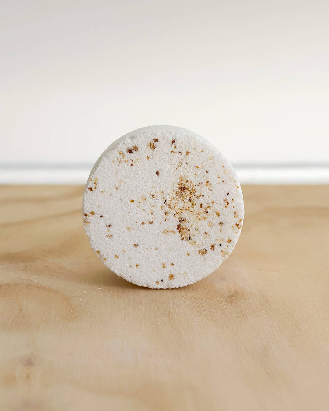 Round white bar with brown specks on a wooden surface