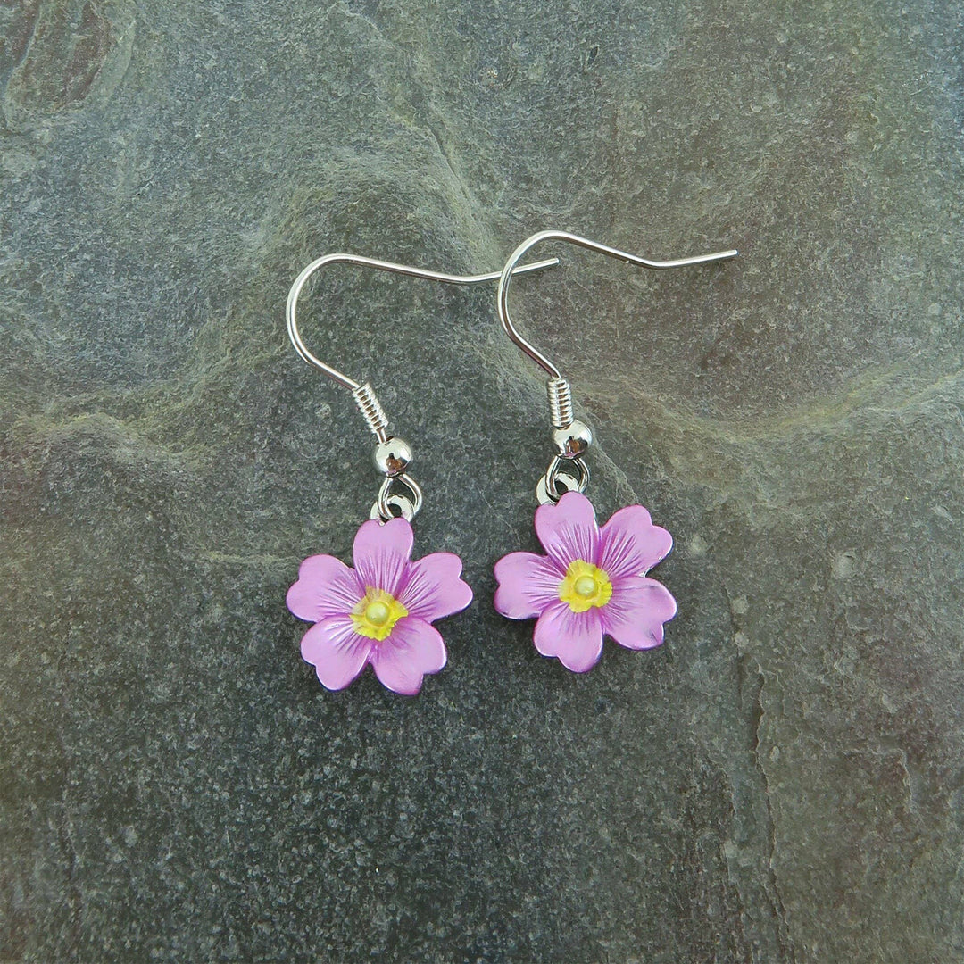Pair of pink flower earrings on a gray stone background