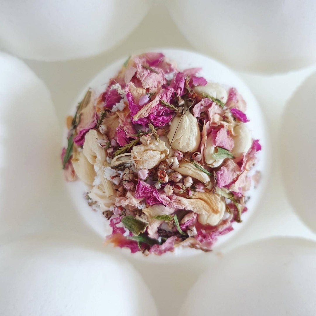 Decorative soap with dried flowers and herbs on a white background