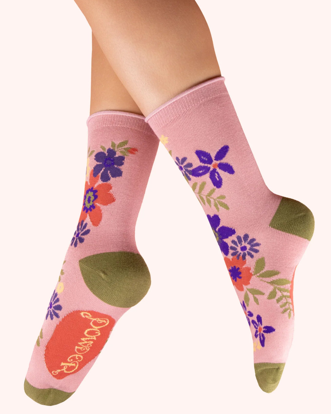 Pink socks with floral designs and 'Pretty' text on a white background
