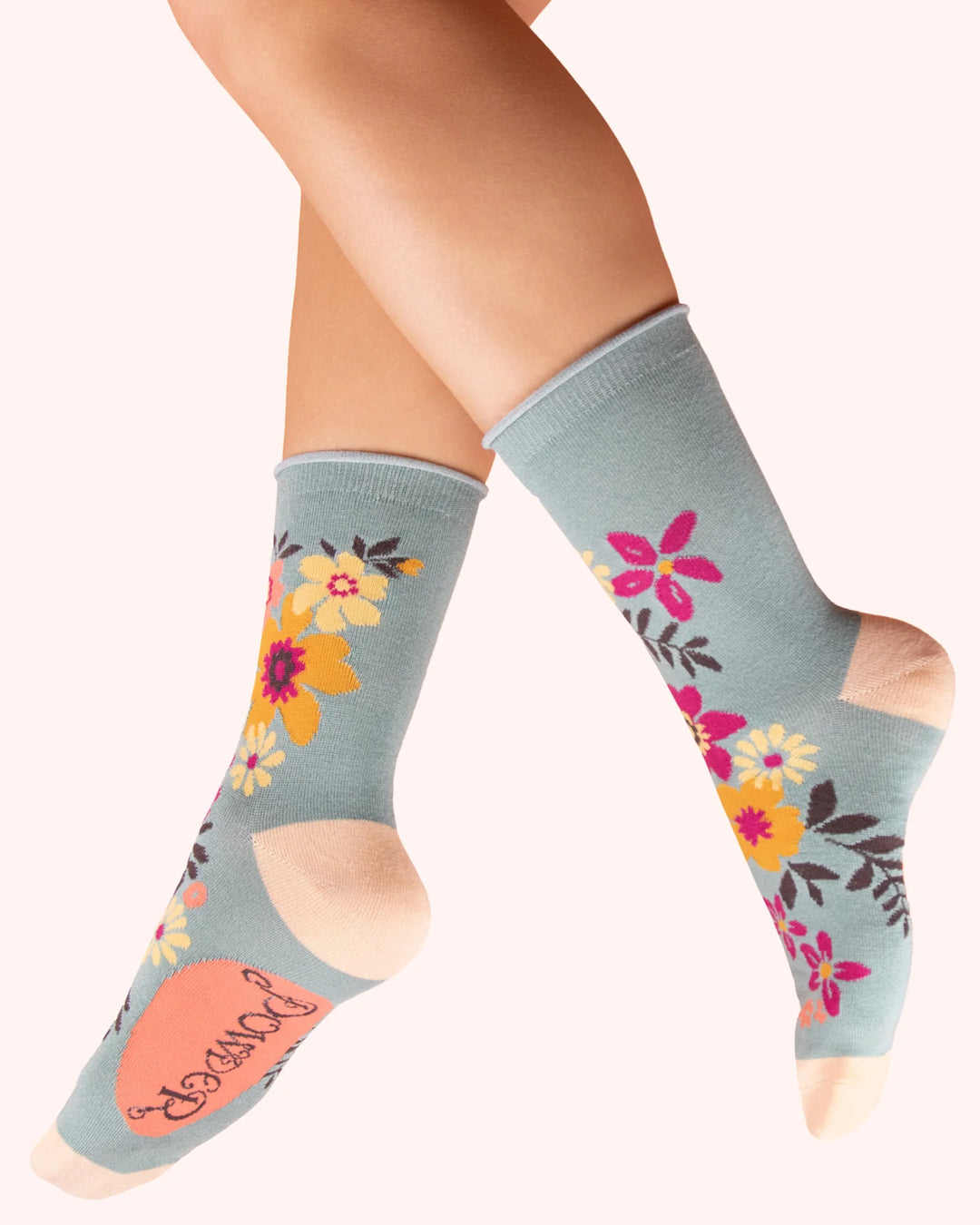 Floral-patterned socks worn by a person on a white background