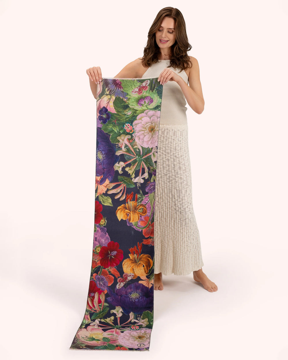Woman holding a long, colorful floral scarf on a white background