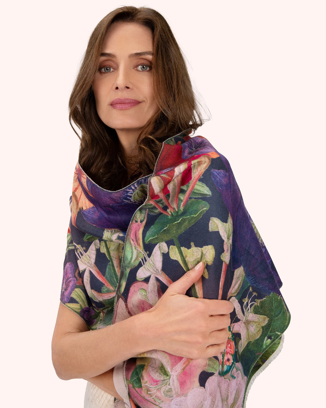 Woman wearing a colorful floral scarf on a white background