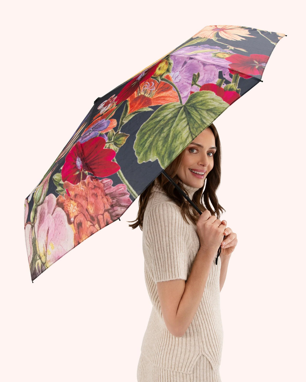 Woman holding a floral umbrella on a white background