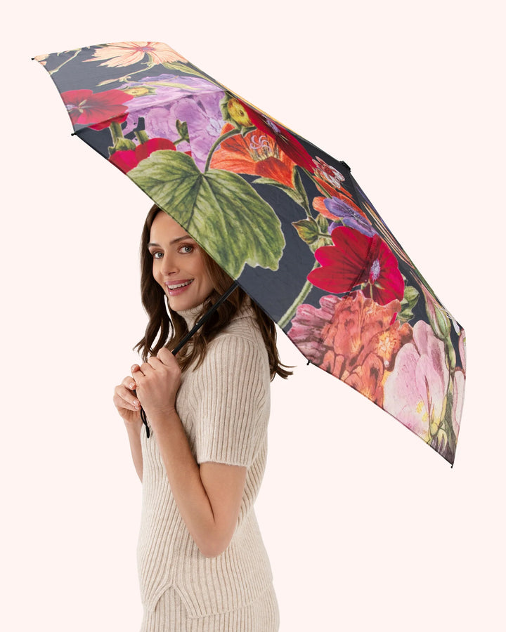 Woman holding a floral umbrella on a white background