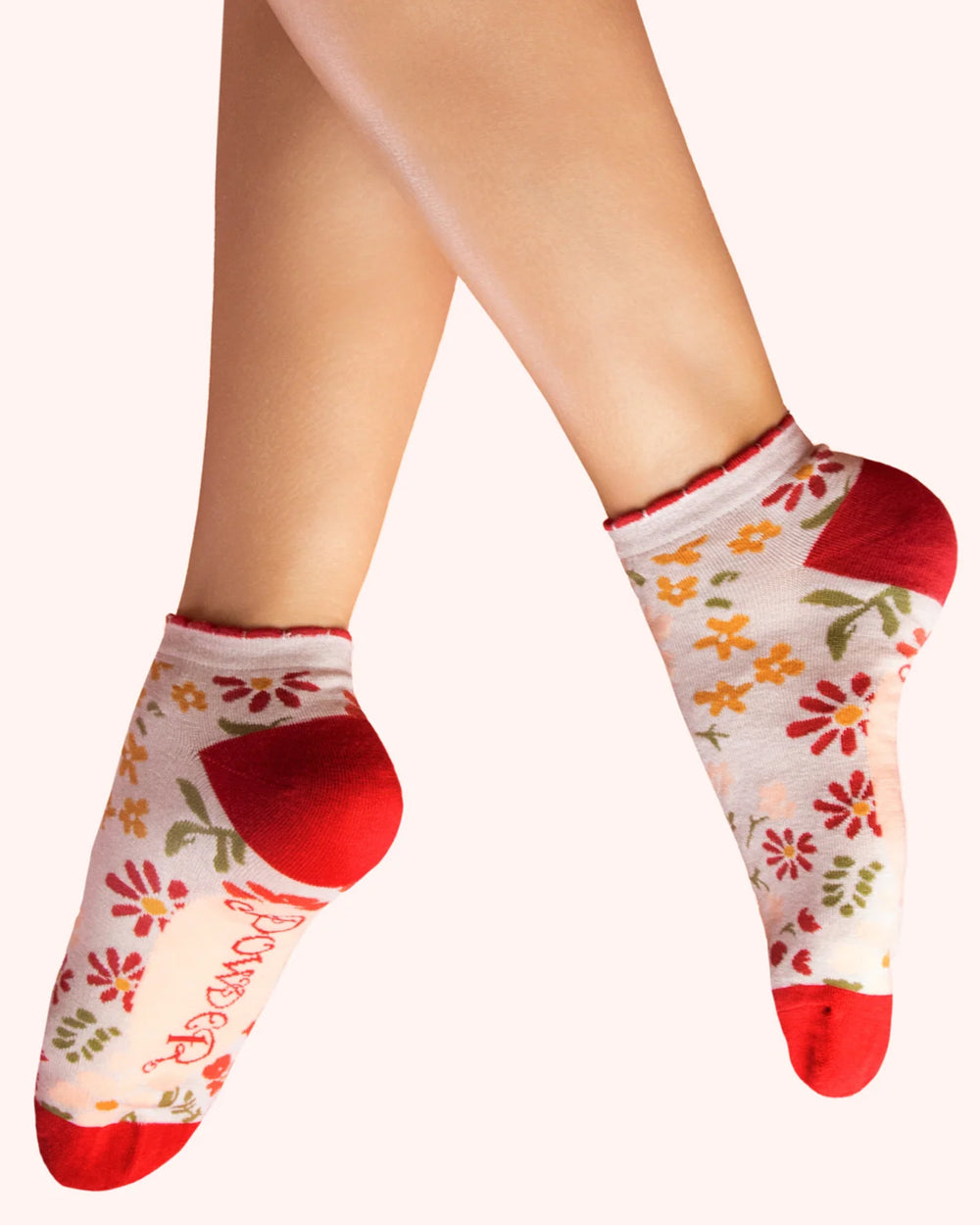 Floral-patterned socks with red toes and cuffs on a white background