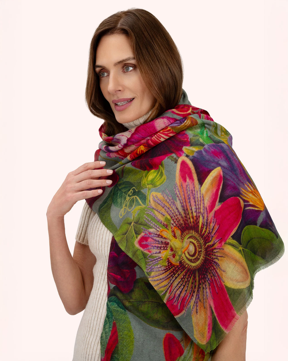 Woman wearing a colorful floral scarf on a white background