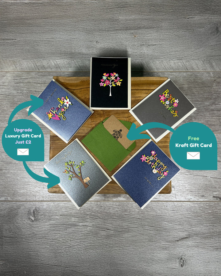 Collection of greeting cards on a wooden surface with gift card options.