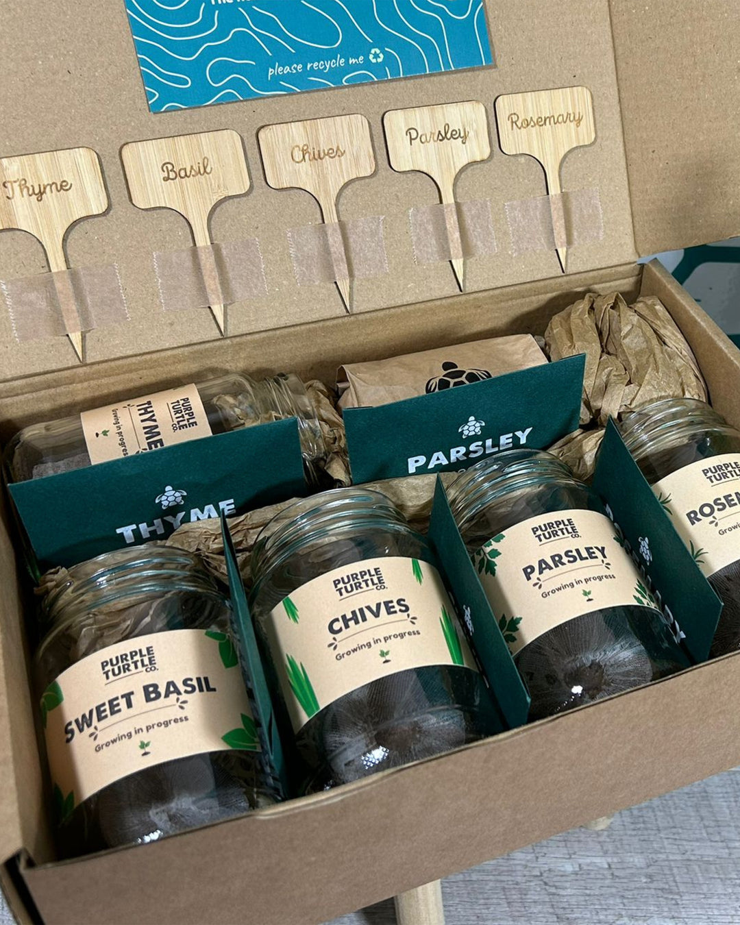 Set of herb jars with labels and wooden name tags in a box