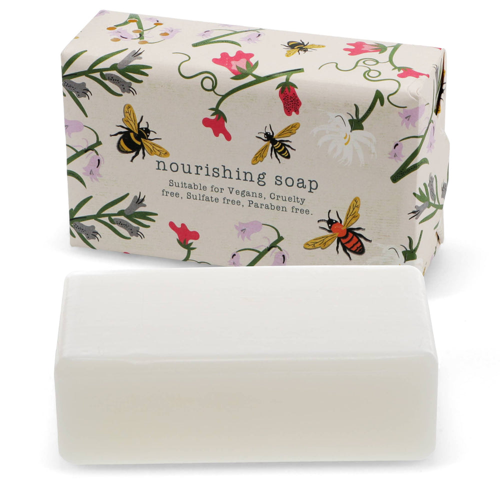 Bar of soap with a decorative packaging featuring bees and flowers on a white background