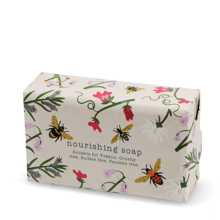 Bar of soap with floral and bee design on a white background