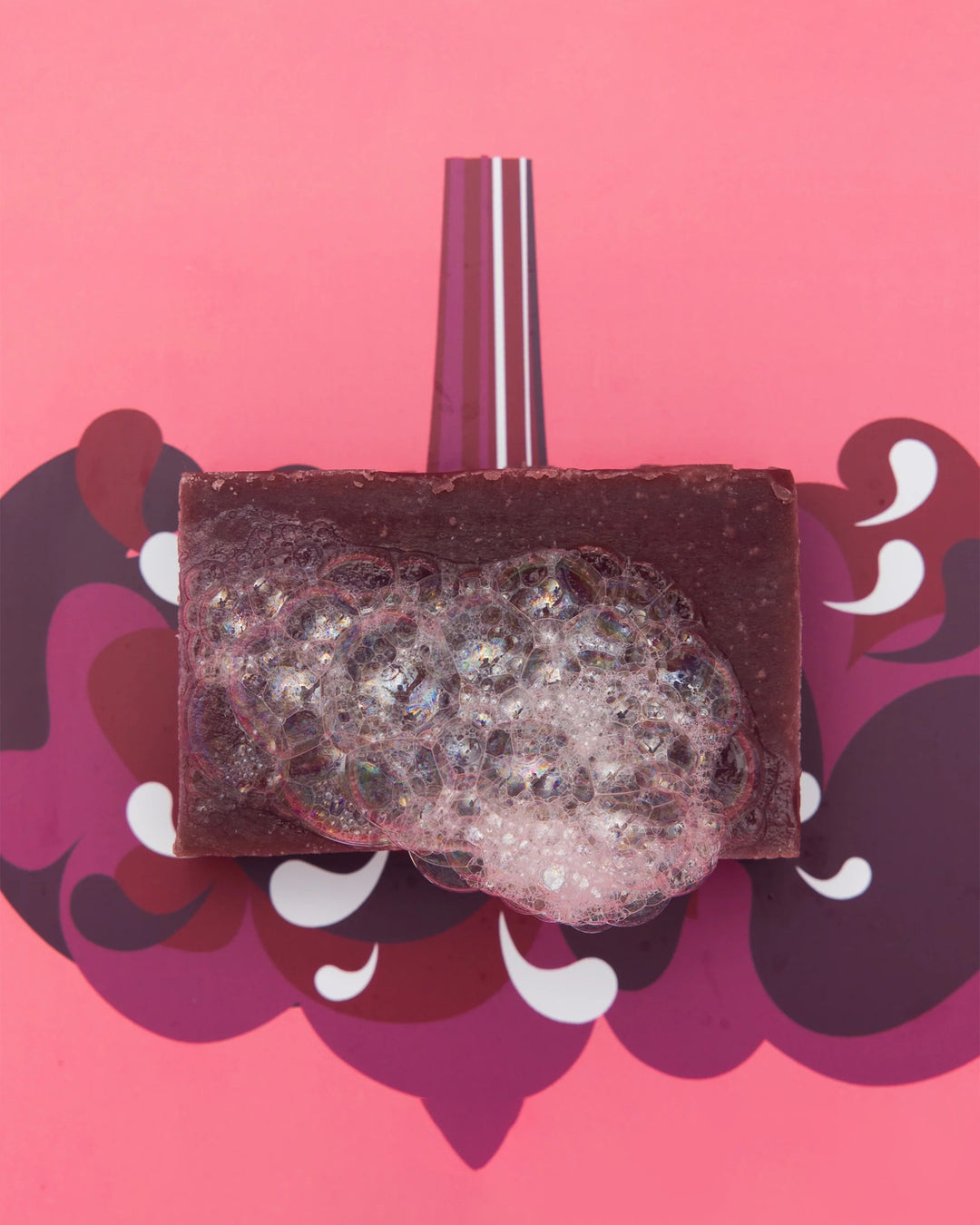 Decorative soap with glittery top on a pink background