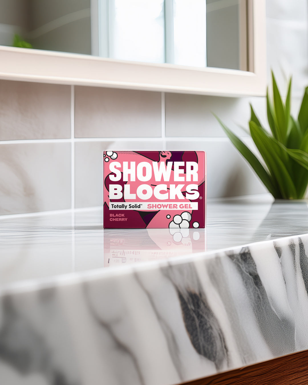 Shower Blocks packaging on a marble shelf with a plant in the background