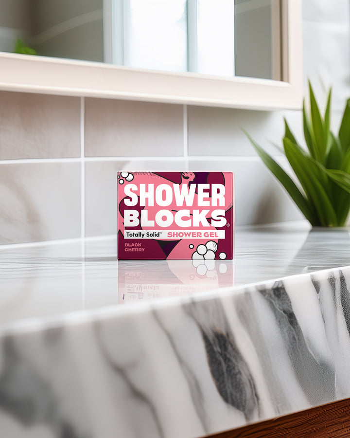 Shower Blocks packaging on a marble shelf with a plant in the background