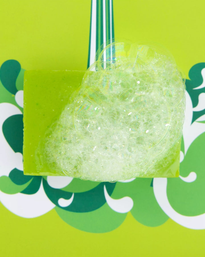 Green bath bomb with a green background featuring floral patterns