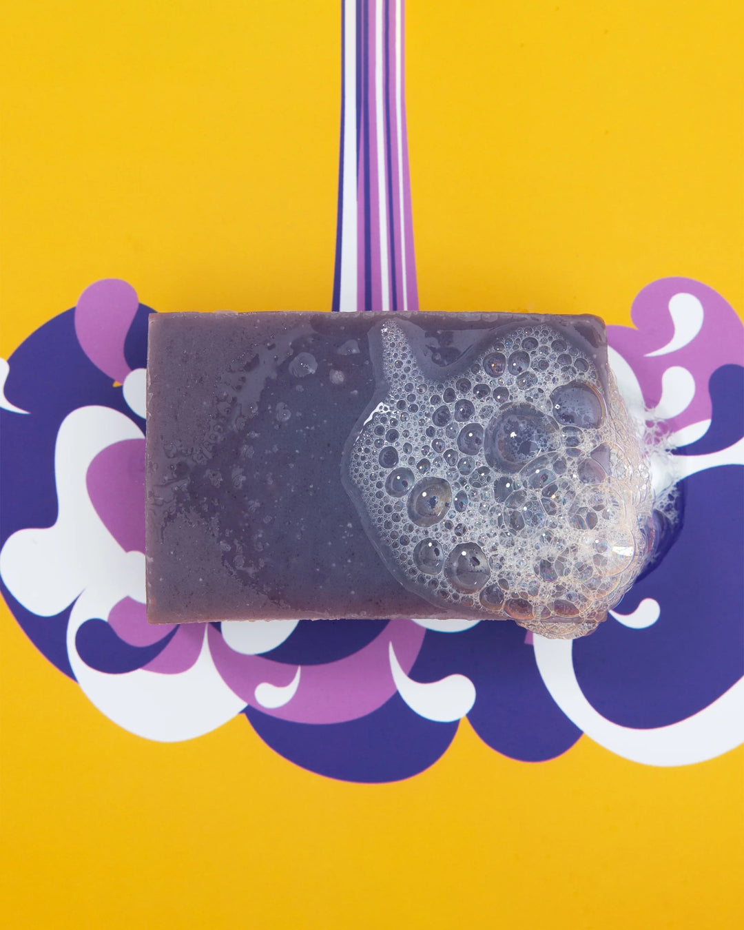 Bar of soap with lather on a colorful background