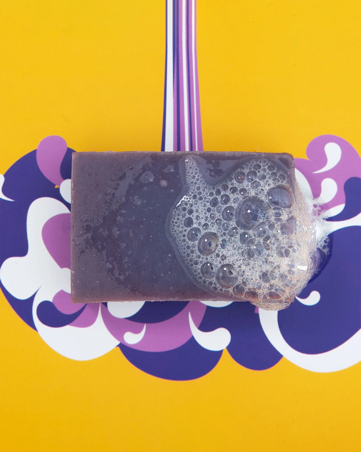 Bar of soap with lather on a colorful background
