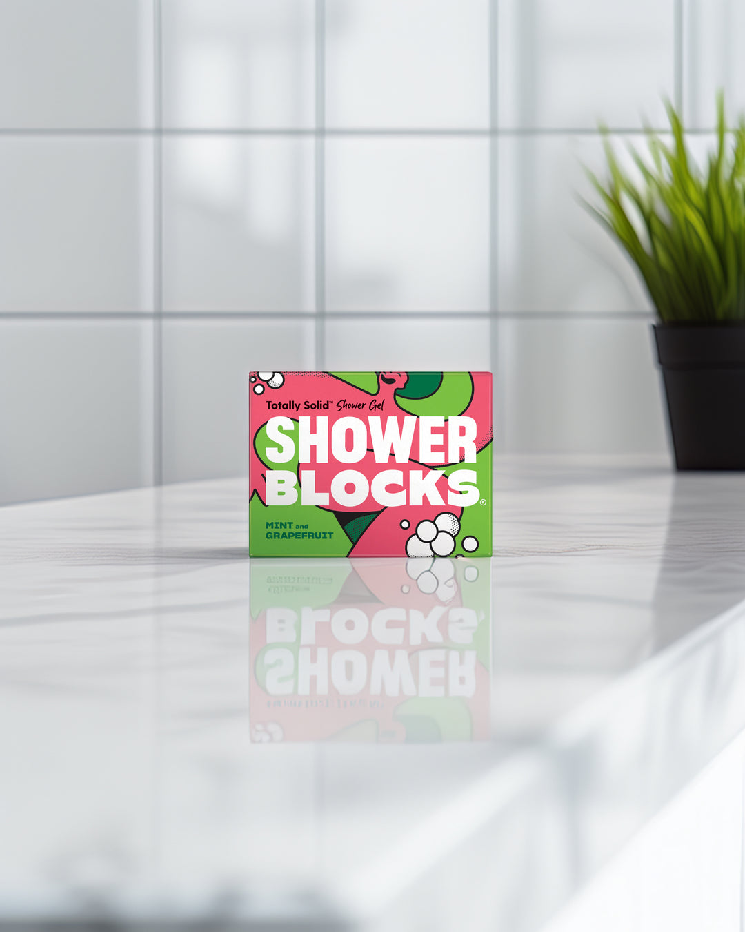 Box of Shower Blocks on a reflective surface with a tiled wall background