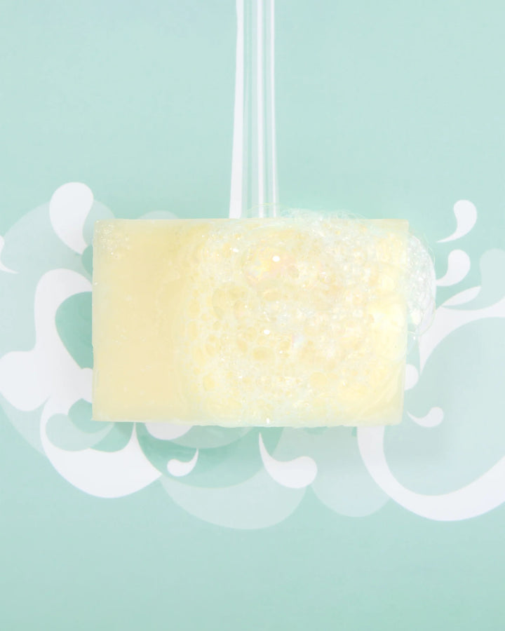 Yellow soap bar with decorative elements on a light blue background