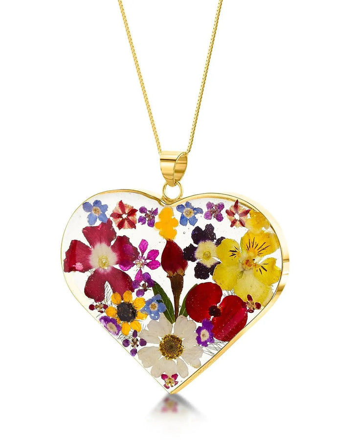 Heart-shaped pendant with colorful flowers on a gold chain against a white background
