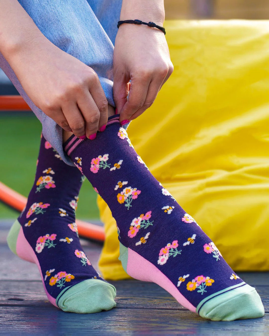 Person wearing floral-patterned socks with a colorful background