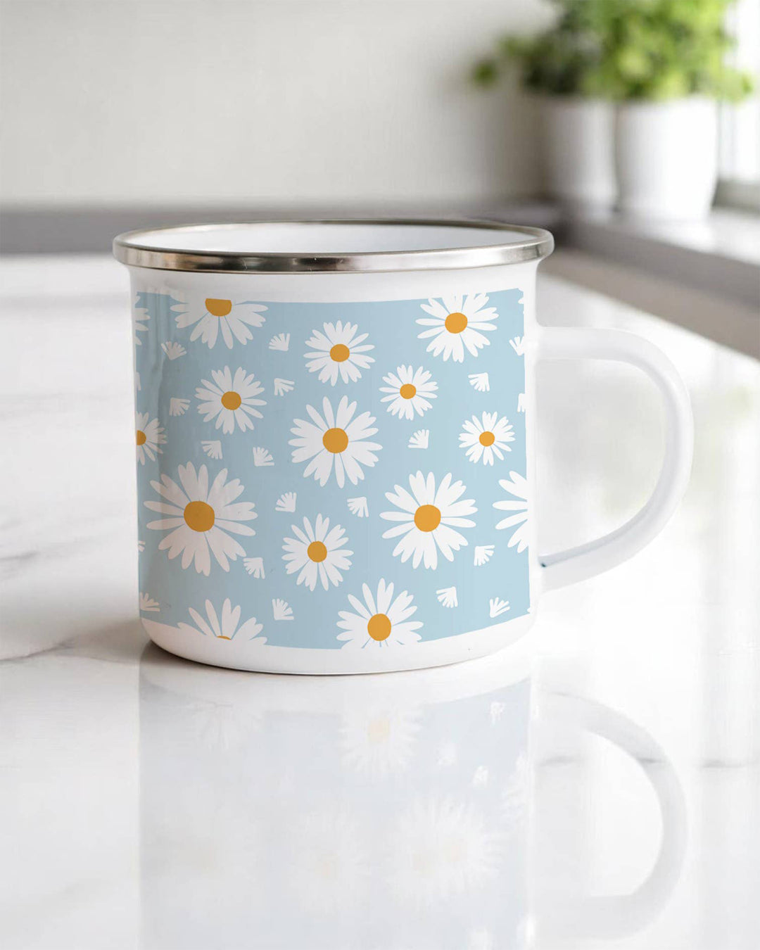 Enamel mug with daisy pattern on a light blue background, placed on a white surface.