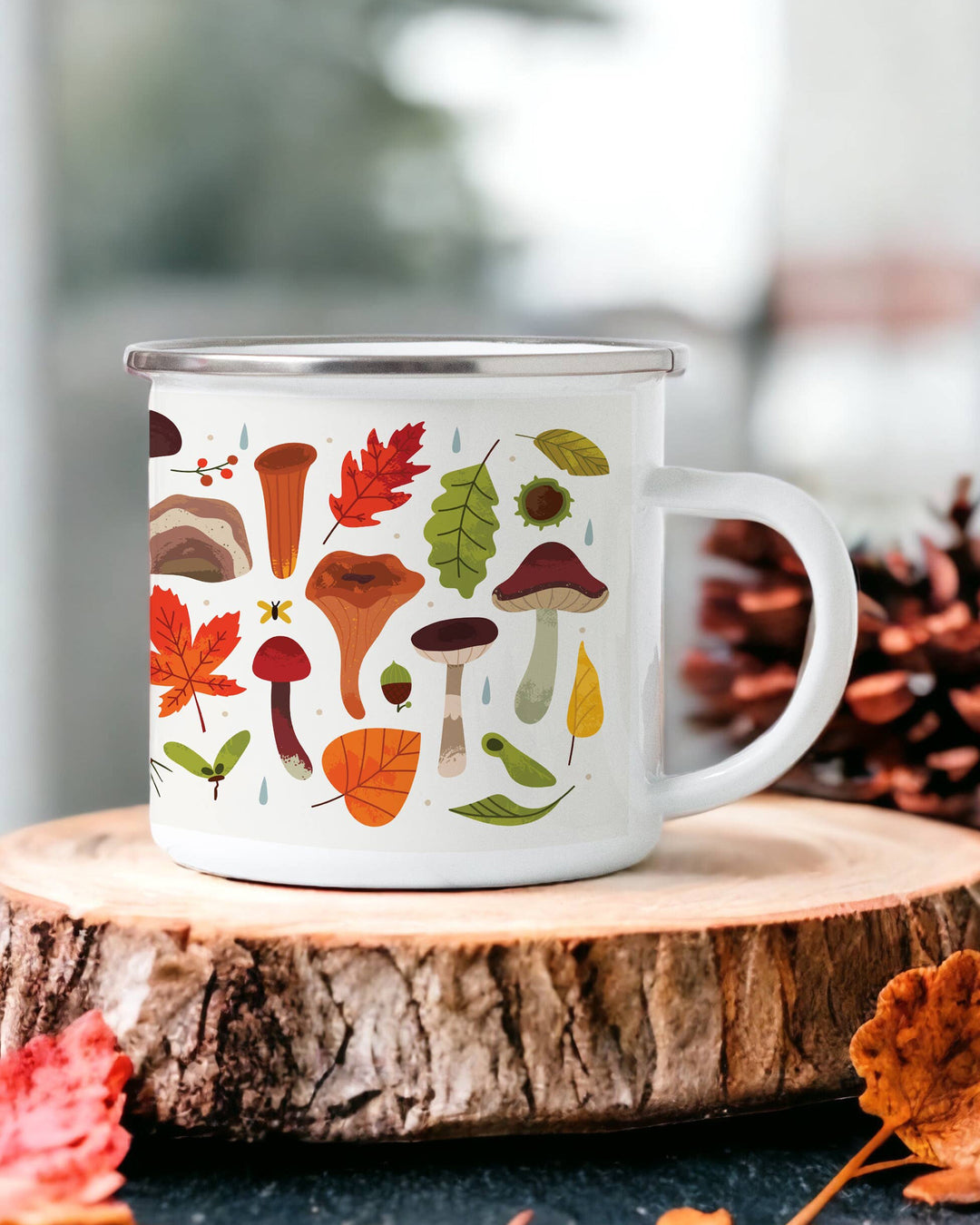 White mug with autumn-themed design of leaves and mushrooms on a wooden surface.