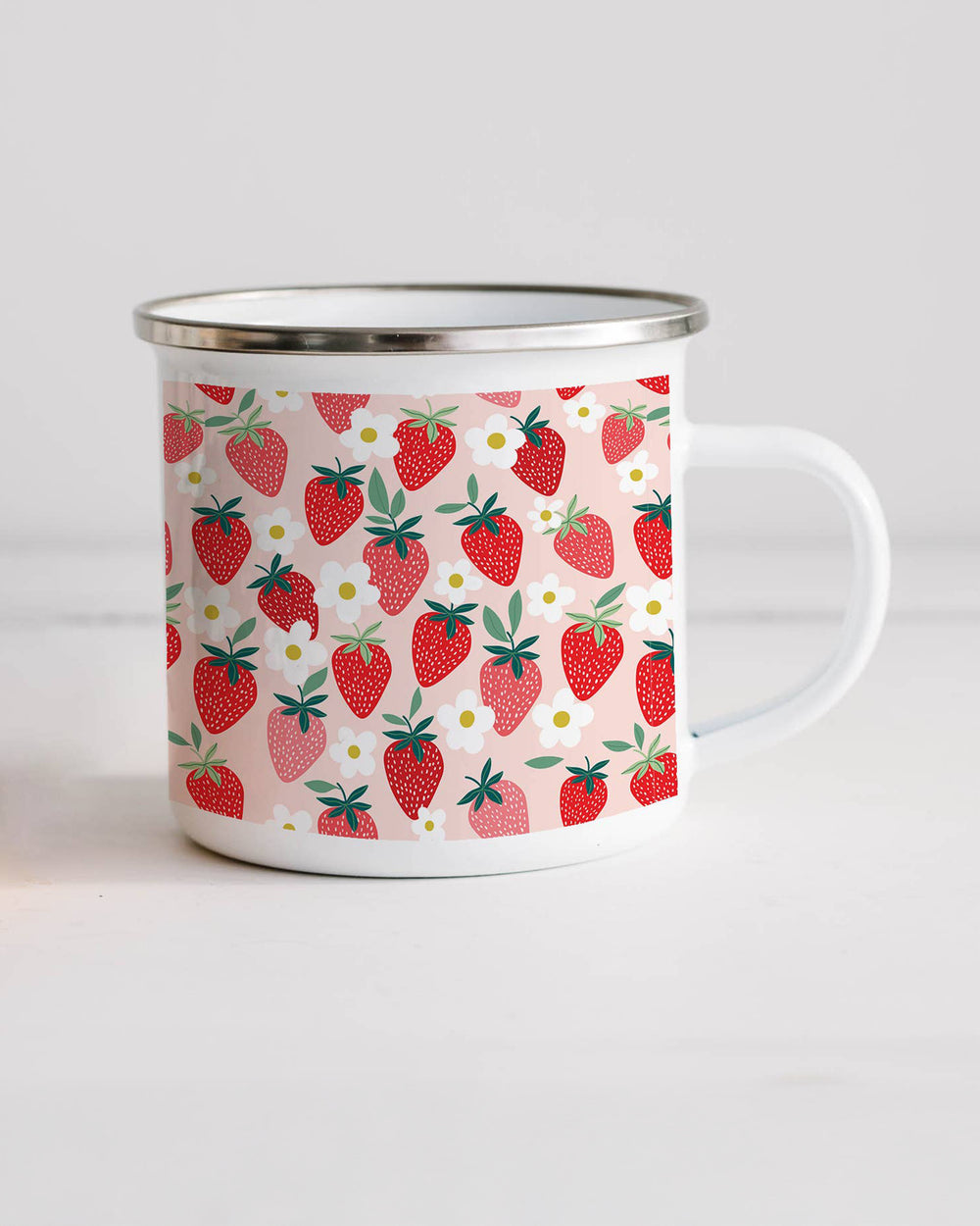 Enamel mug with strawberry pattern on a white background
