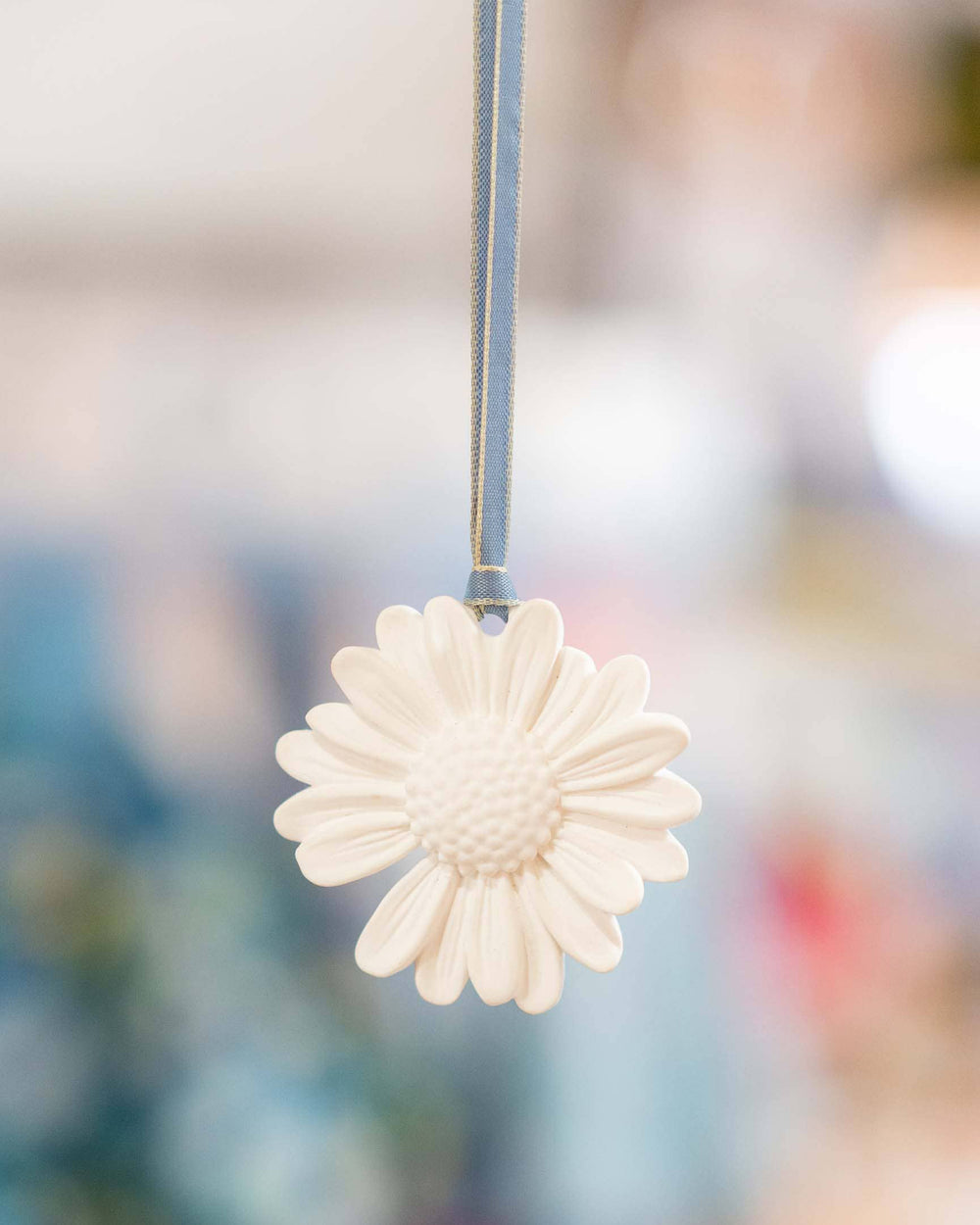 White flower-shaped ornament hanging against a blurred background
